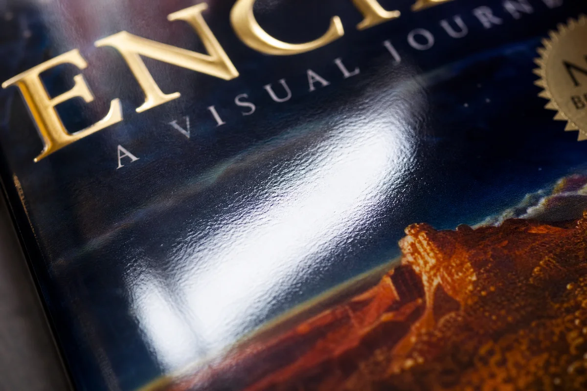 Close-up of a glossy laminated book cover reflecting light and showing vibrant colors