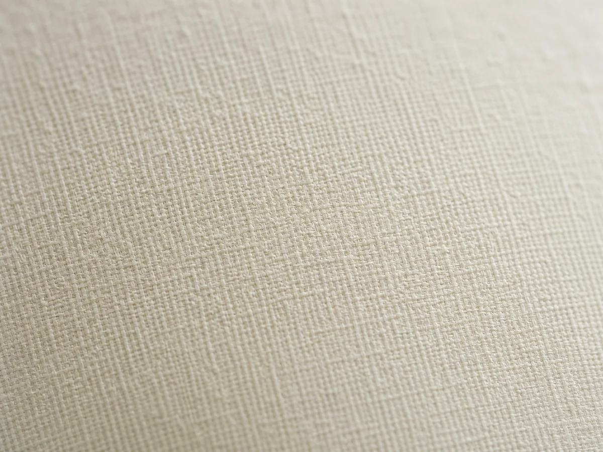 Macro close-up of linen paper surface showing fine woven fabric-like crosshatch texture pattern in neutral off-white