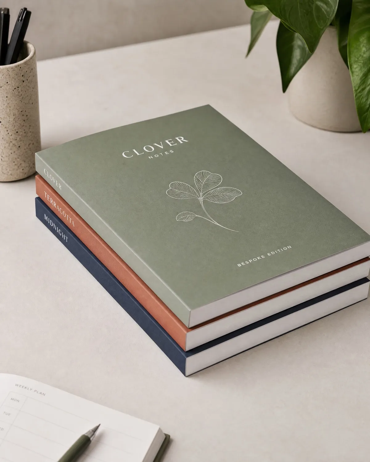Stack of custom softcover notebooks with matte laminated covers demonstrating perfect binding for bulk promotional orders