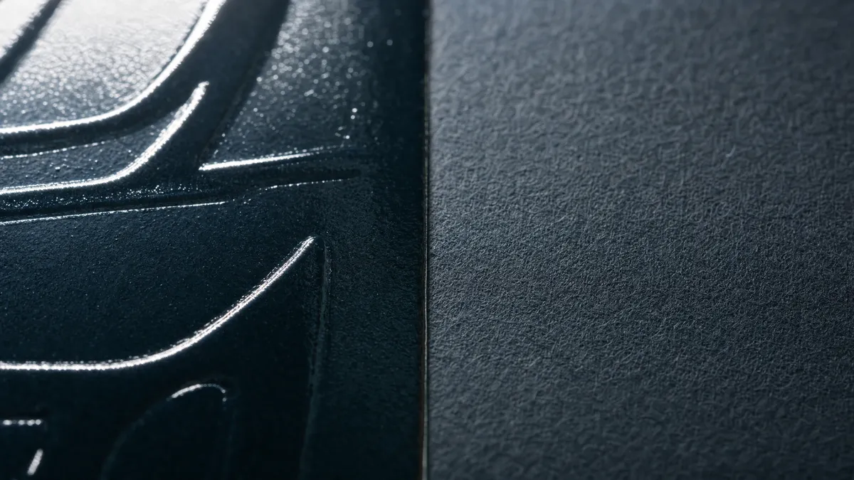 Close-up macro shot of spot UV raised glossy coating on matte paper surface