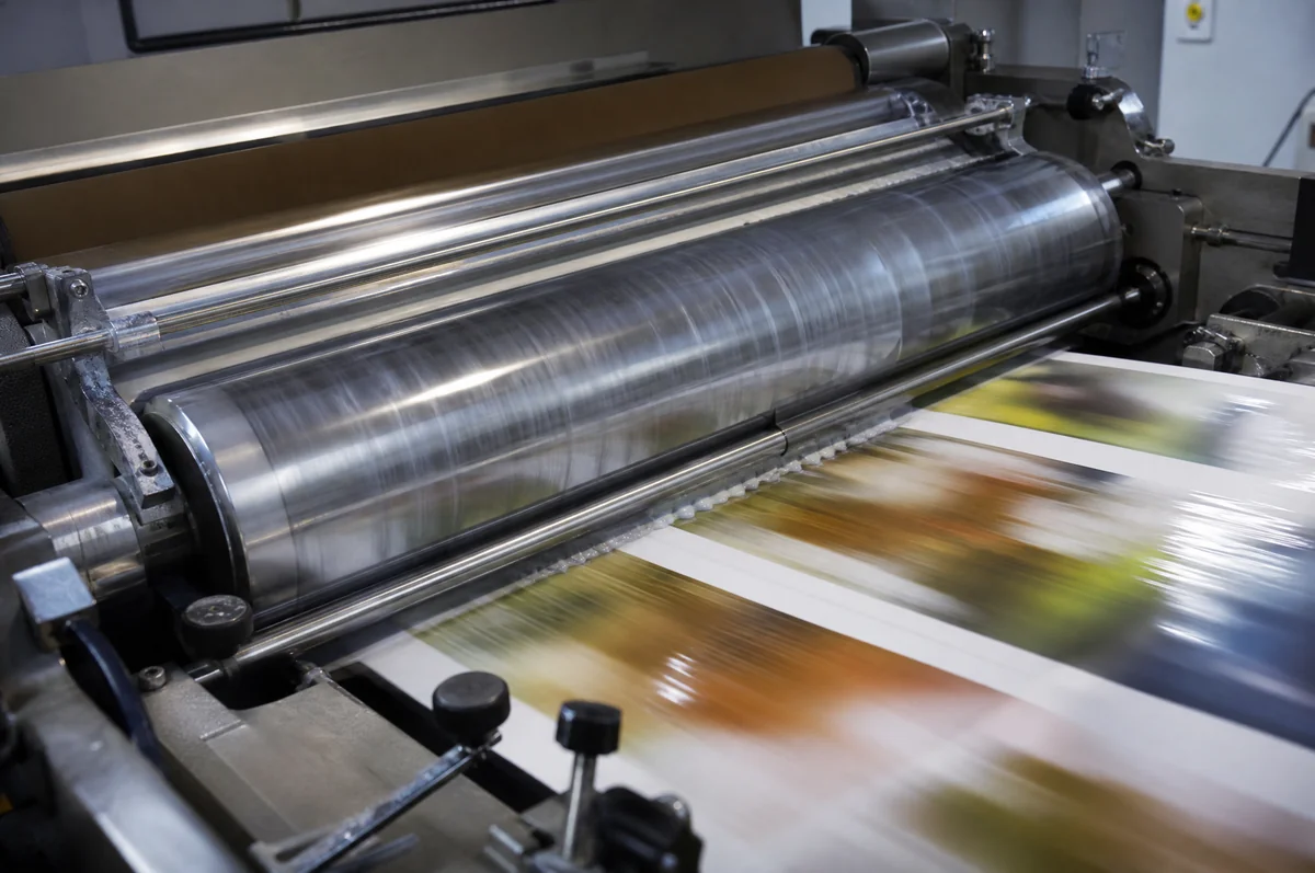 Printing press applying varnish coating to printed sheets on a production line