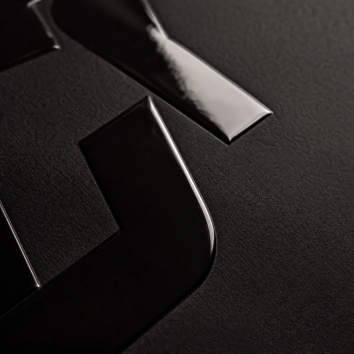 Close-up of a business card with spot gloss varnish highlighting the logo against a matte background