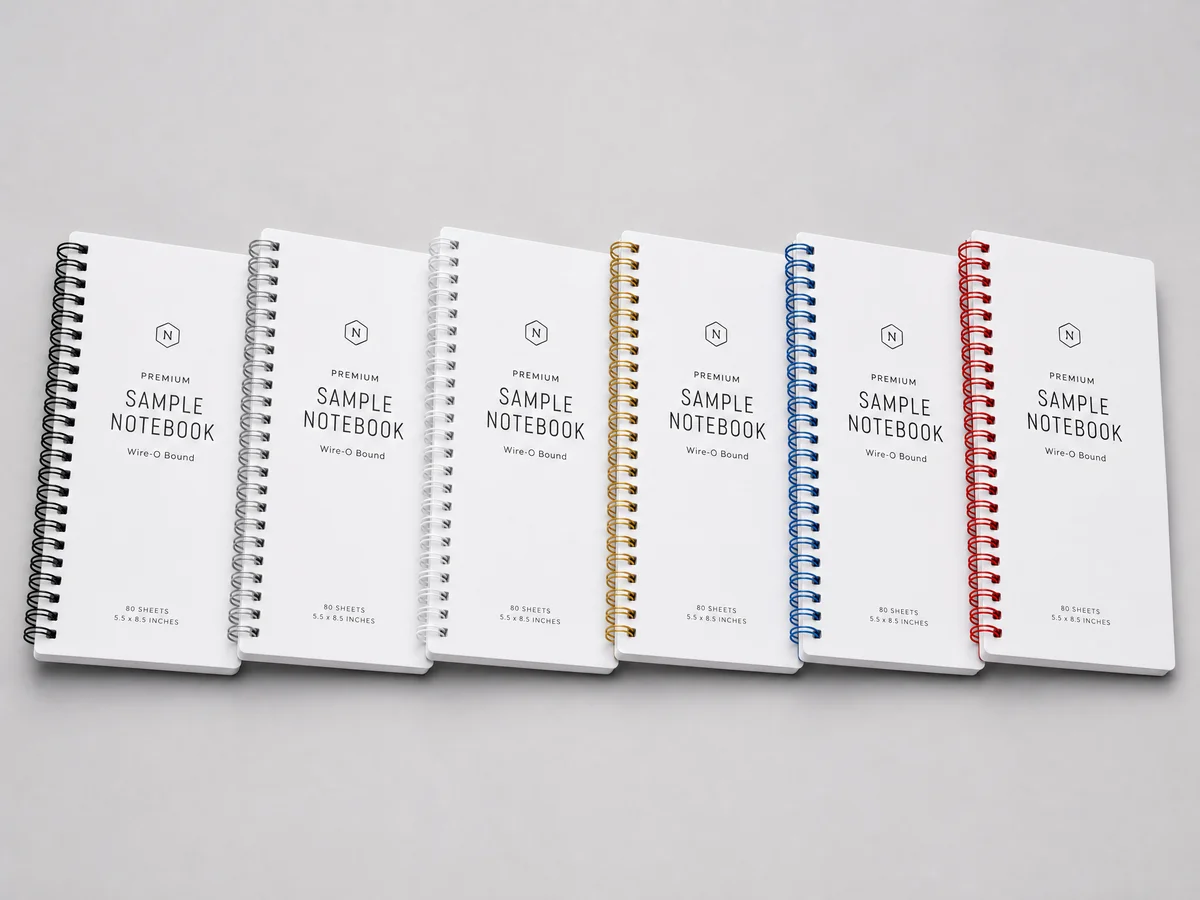 Collection of Wire-O bound books showing different wire color options including black, silver, gold, blue, and red